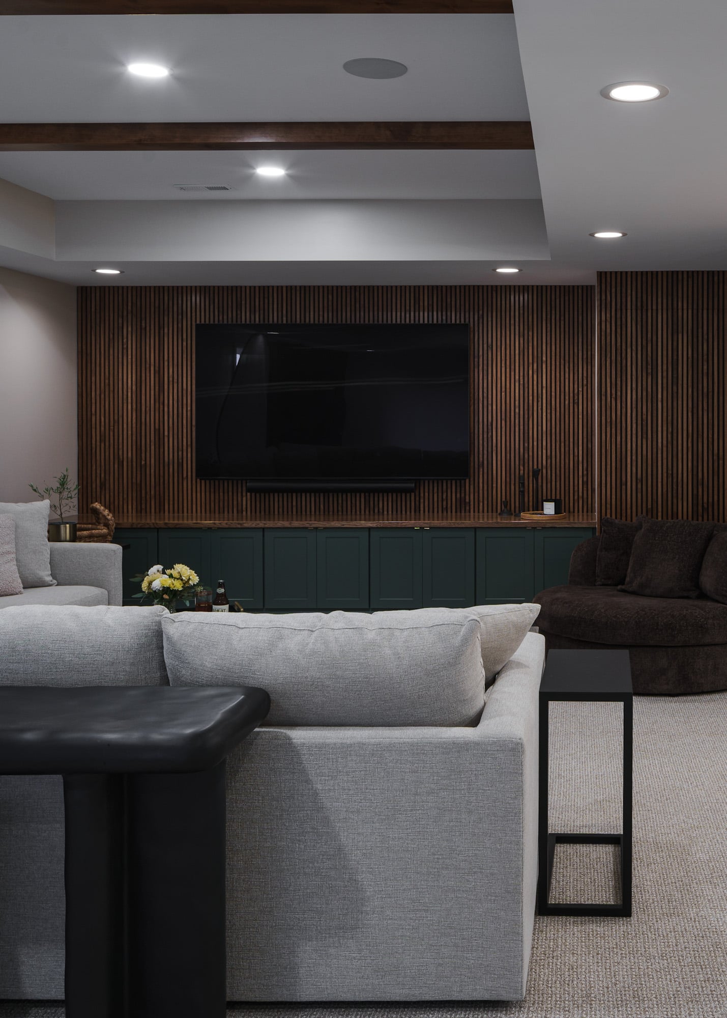 Green cabinets | slat wall behind mounted tv | Finished Basement Remodel