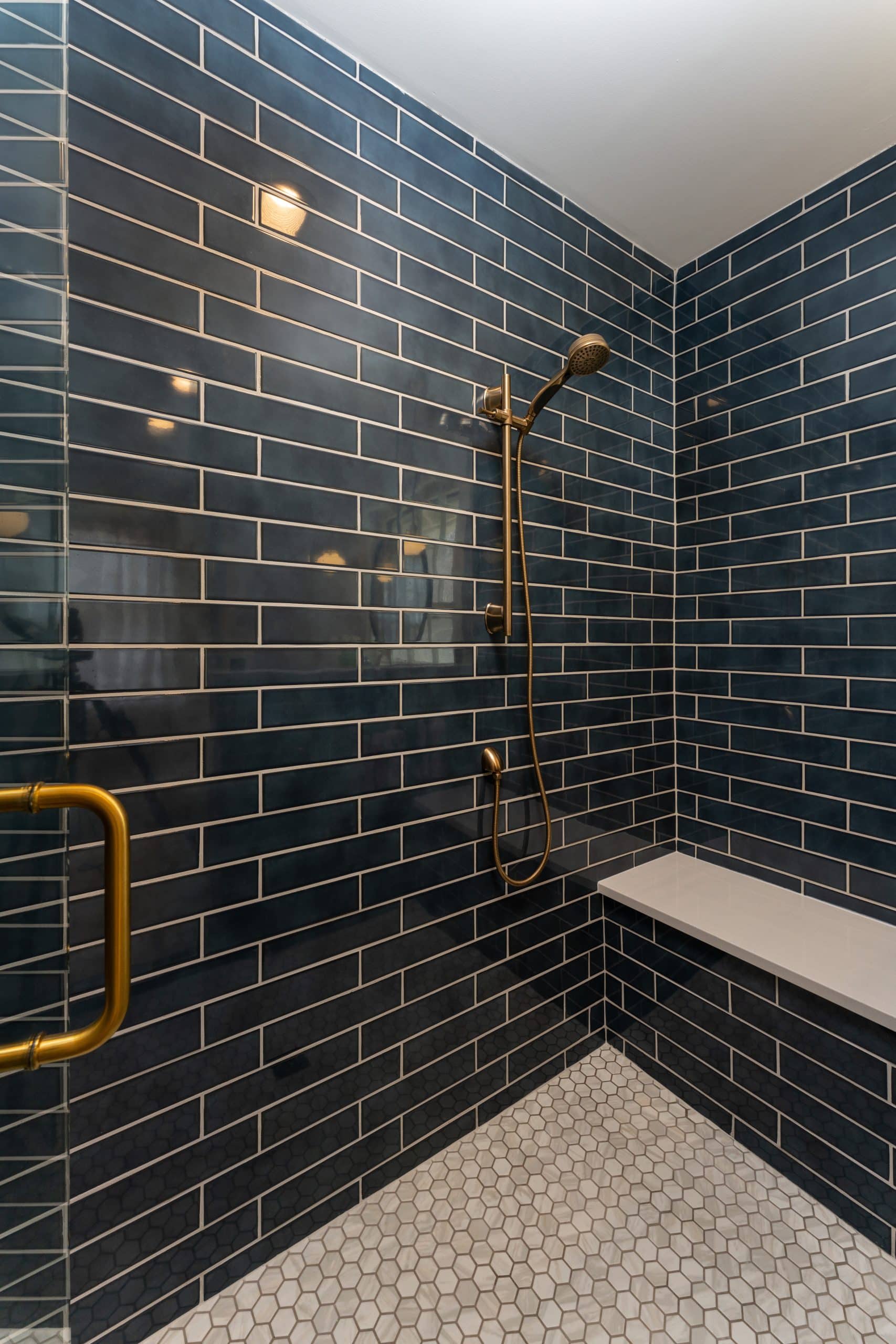 curbless shower with large bench seat and brass hardware and deep navy tile in guest hall bathroom remodel curbless shower with large bench seat and brass hardware and deep navy tile in guest hall bathroom remodel