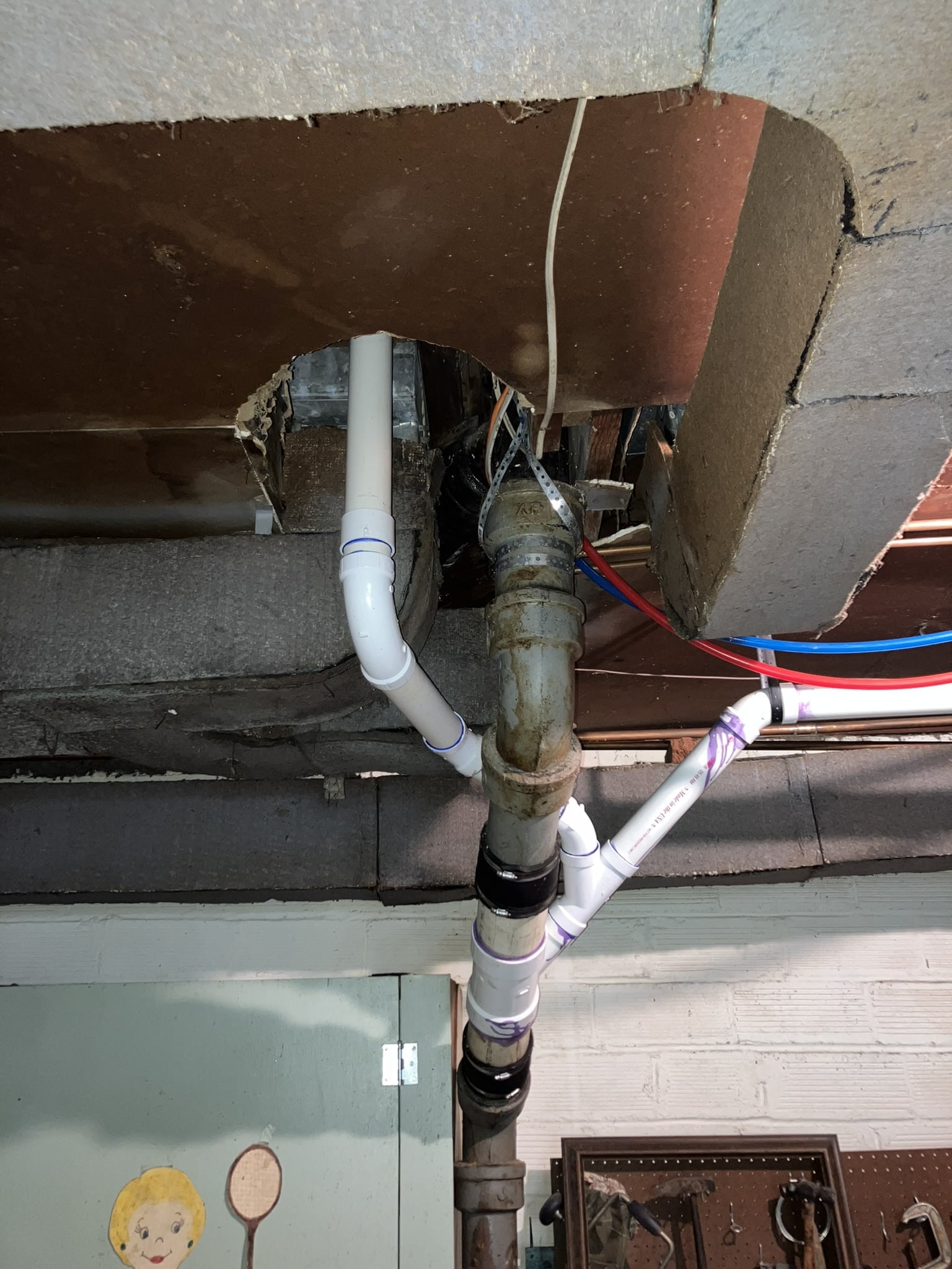 older-home plumbing concerns Old cast-iron and newer PVC plumbing crowded around ductwork in an older Kansas City home.