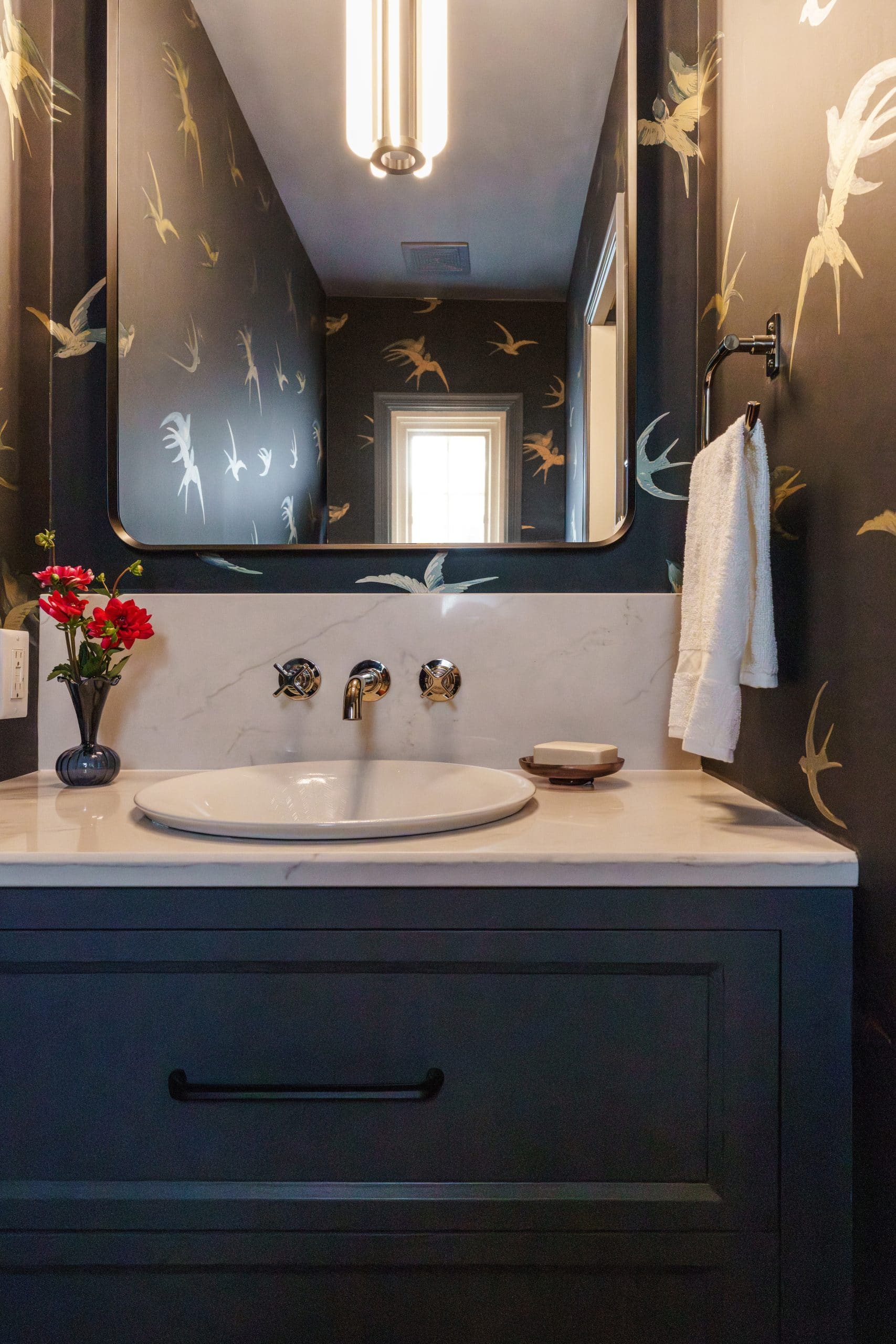 powder bath remodel with dark vanity and bold wallpaper