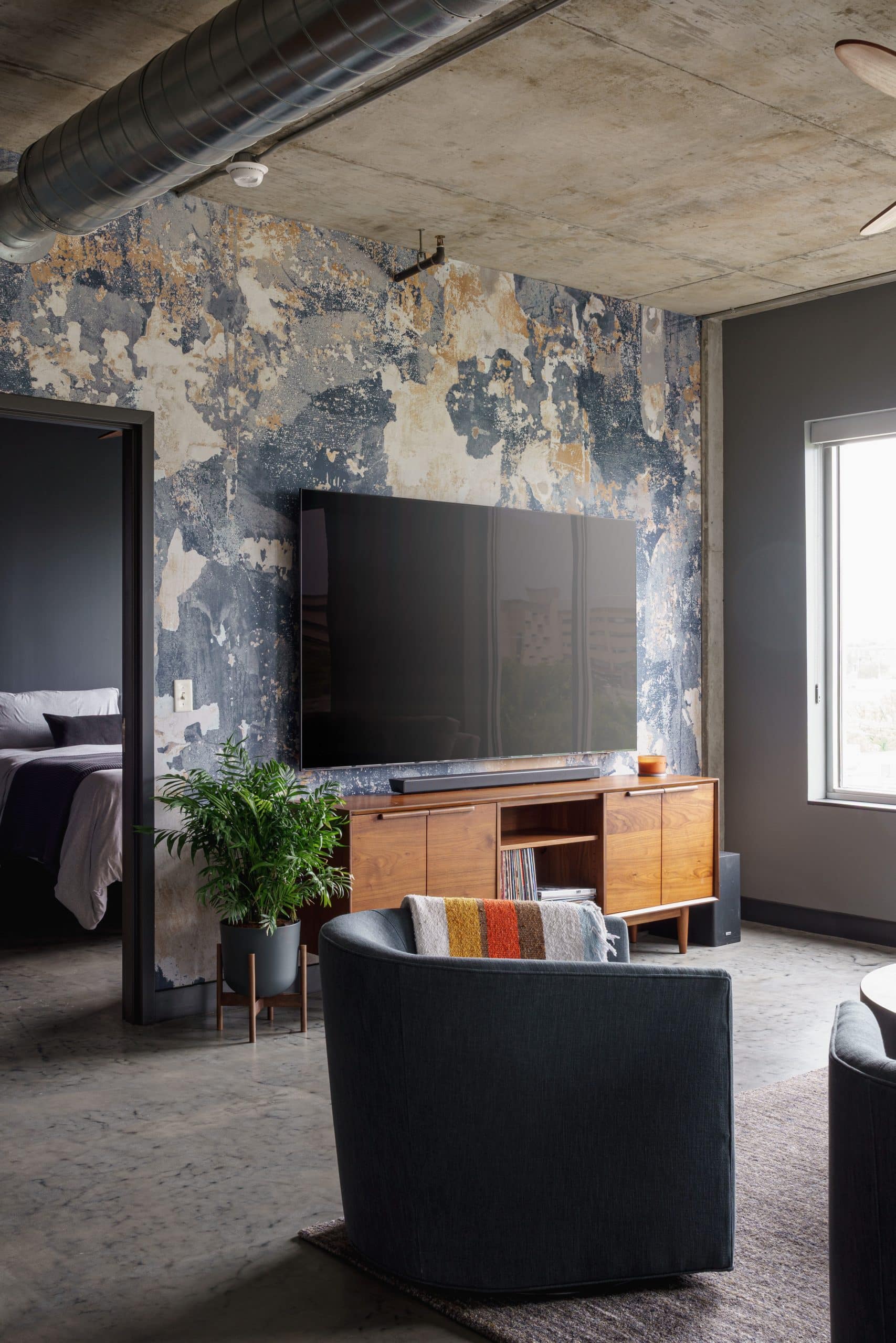 condo remodel with industrial feel and texture wallpaper in living area in westport kc